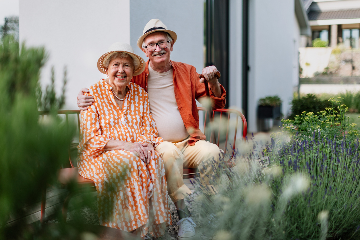 Smiling 80 plus senior couple in their garden