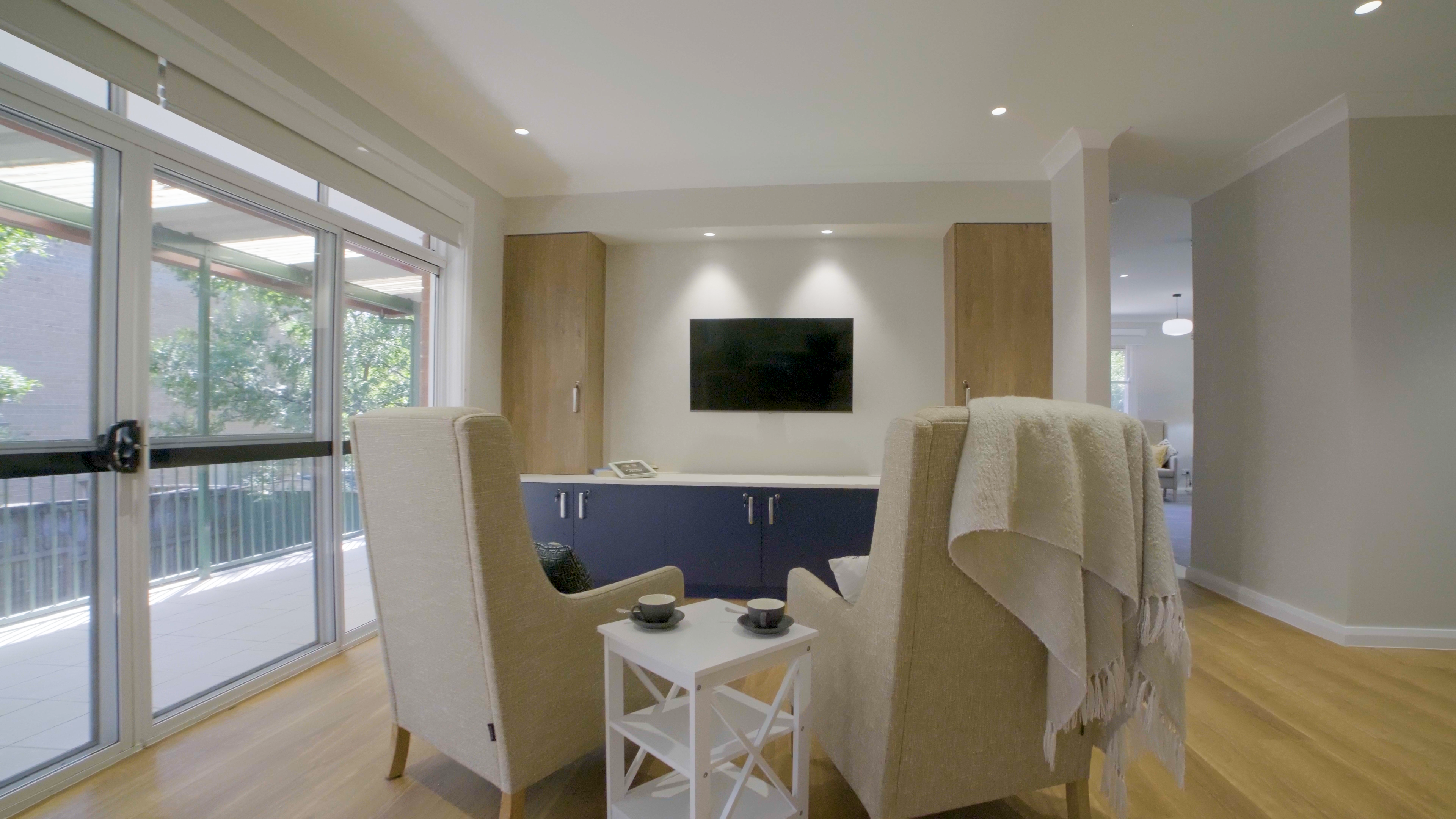 Cozy living room with a wall-mounted TV and a comfortable sofa