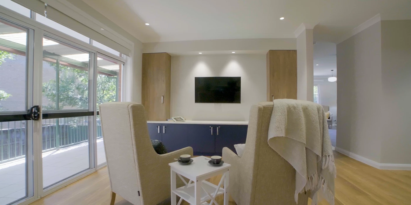 Cozy living room with a wall-mounted TV and a comfortable sofa