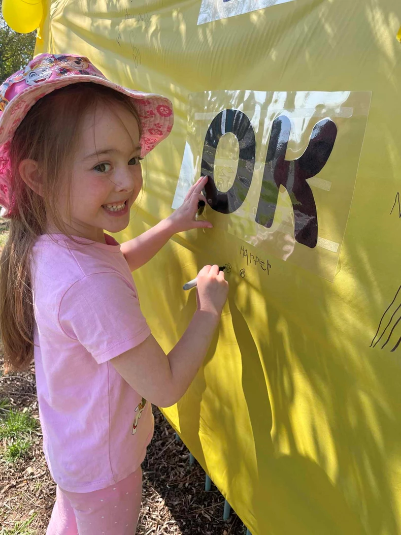 Student writing message of hope on RUOK Day